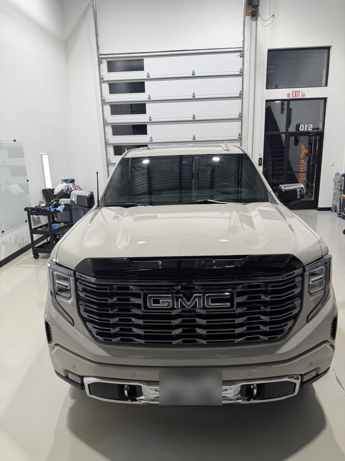 Front view of a ceramic coated GMC Sierra Denali Ultimate showing hood gloss and gloss-black grille