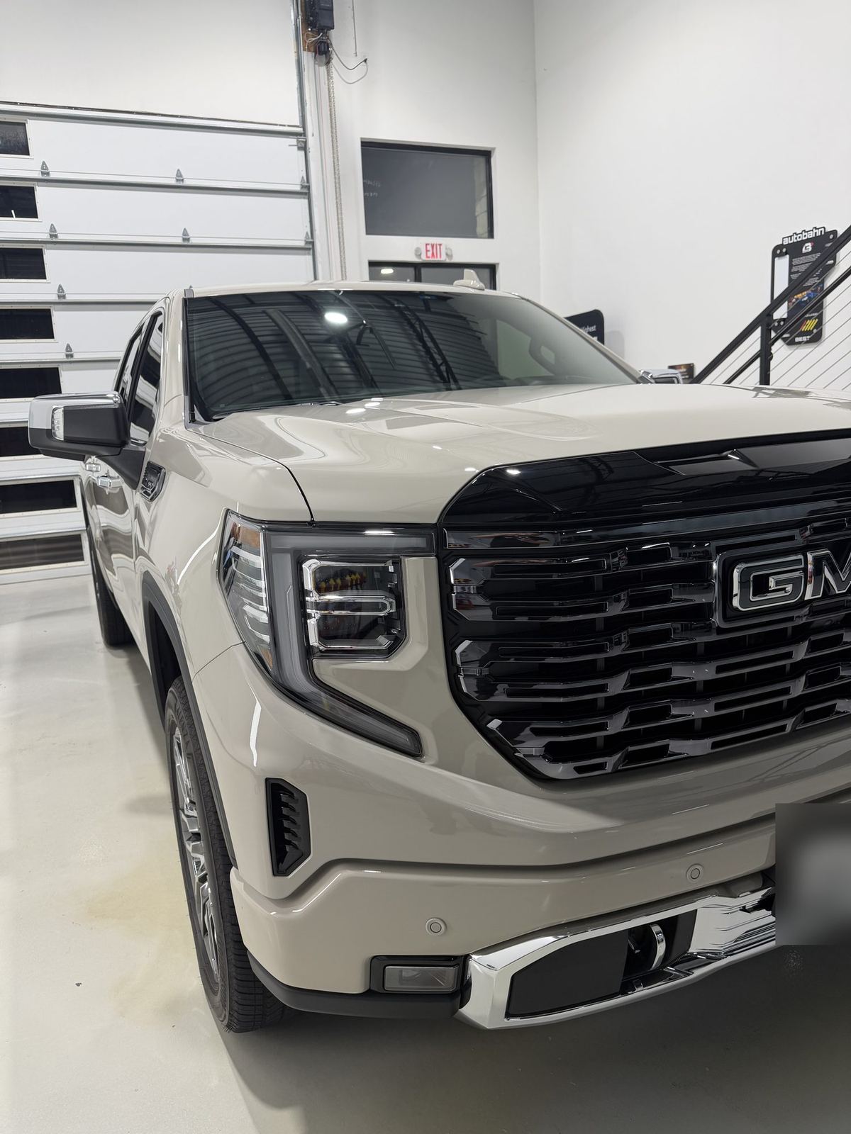 Close-up of the headlight, fender and gloss-black grille on a ceramic coated GMC Sierra Denali Ultimate