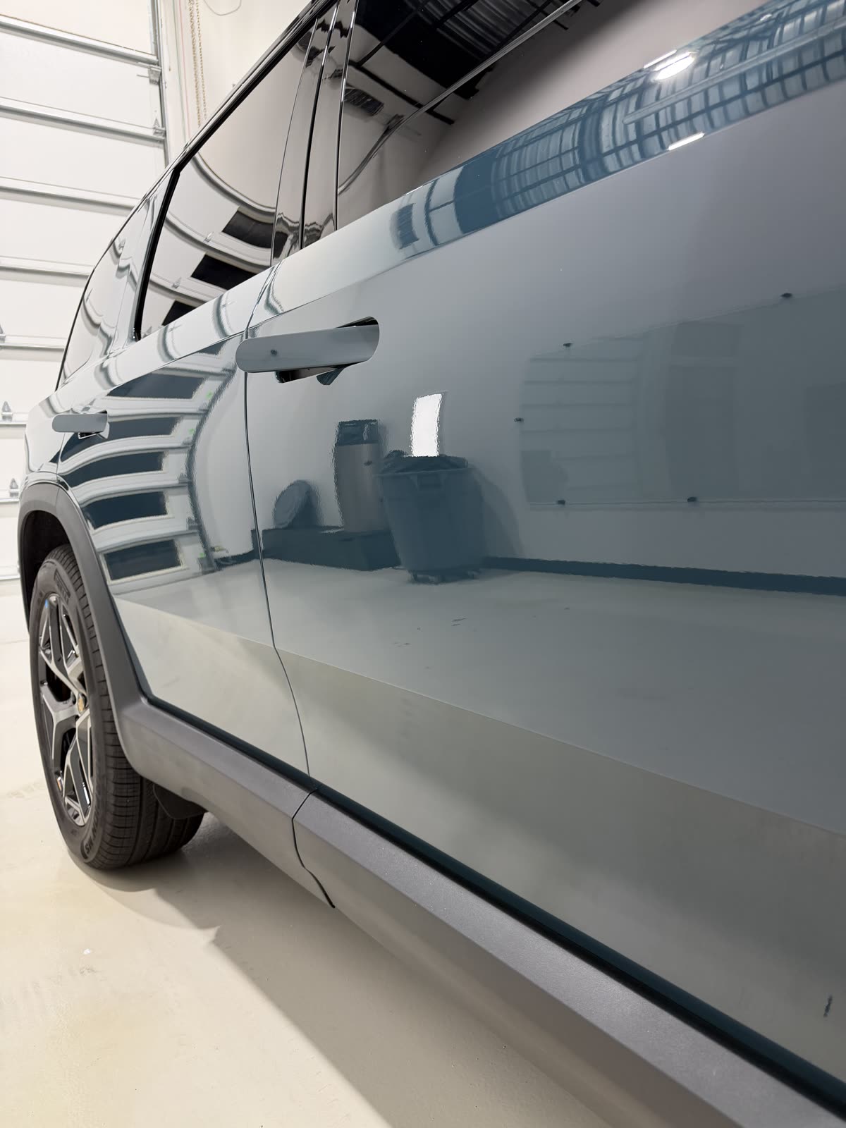 Reflection in the ceramic coated door paint of a Rivian R1S